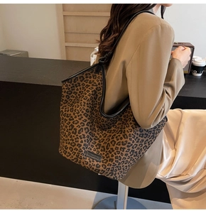 Lifestyle view of large leopard print tote bag styled with a khaki blazer on model