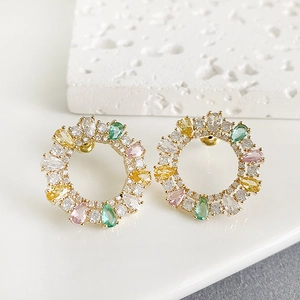 Detail of floral hoop earrings with colorful teardrop-shaped zircon stones in gold plating