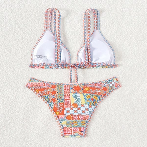 Women's chic printed bikini set with mosaic patterns on a soft white fabric flat lay