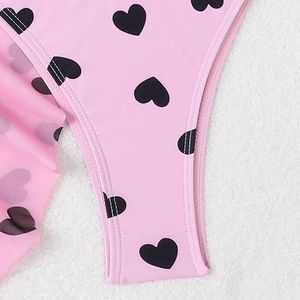 Détail macro du tissu rose à motif cœurs pour maillot de bain avec couture à double aiguille