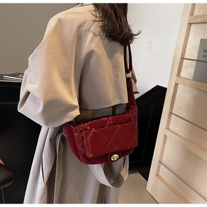 Detail of red quilted patent leather crossbody bag with golden twist lock closure