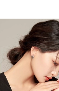 Close-up of elegant silver double hoop earrings worn on a female ear model