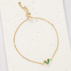 Detail of adjustable gold bracelet with micro-pave green zircon heart and bolo slider clasp