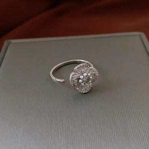 Detailed macro view of an adjustable silver ring featuring pearls and zircon flowers