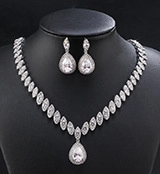 Detail of leaf-shaped zirconia necklace and teardrop earrings on black velvet stand