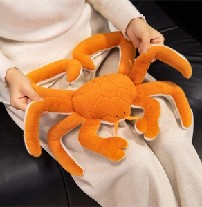 Detailed view of plush crab toy showing orange soft fabric and realistic shell stitching