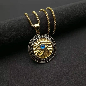 Gold Eye of Horus medallion necklace with blue eye detail on a dark minimalist surface
