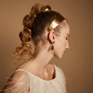 Elegant gold metal ponytail holder and hair cuff accessory set on a fashion model