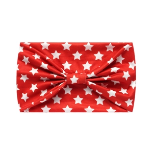 Close-up of red headband with white star pattern and decorative knot on white background