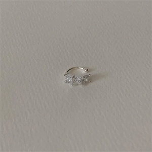 Detail of S925 silver ear cuff with three square-cut sparkling zircons in a minimalist style