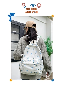 Detail shot of a floral canvas backpack showing the tulip pattern and front pocket cord