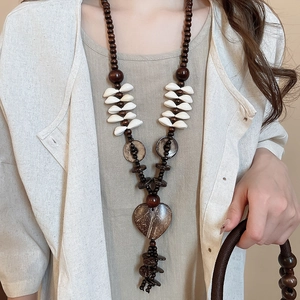 Detailed macro view of bohemian coconut shell heart pendant and natural wood bead necklace