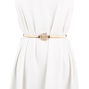 Détail de la ceinture dorée élastique avec boucle pomme et strass sur une robe blanche