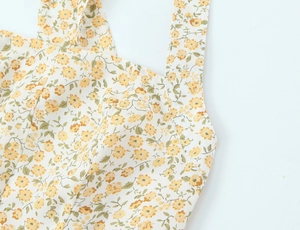 Gros plan détaillé de la couture et du motif floral sur la robe licou jaune à fleurs