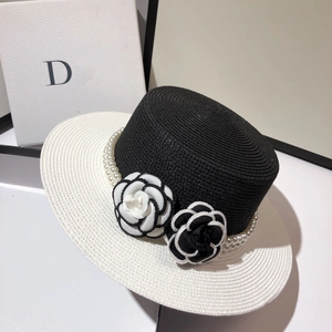 Detail of flat top straw hat featuring elegant camellia flowers and pearl trim decor
