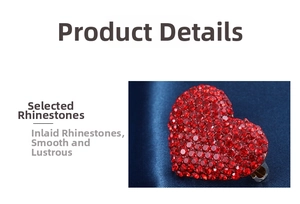 Close-up of heart-shaped brooch with sparkling red rhinestones on blue silk background