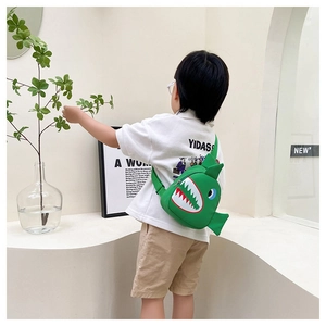 Detail view of the cute green shark-shaped kids chest bag showing canvas fabric and strap