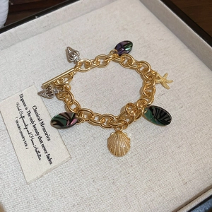Detail shot of golden ocean theme bracelet with shells and starfish charms in a jewelry box