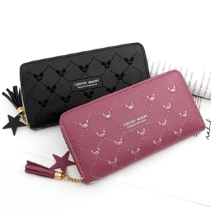 Detail of long quilted PU leather wallets with tassel and star charms in black and burgundy