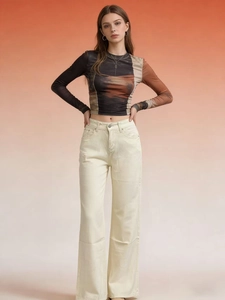 Détail du jean beige taille haute à jambes larges avec un haut à imprimé abstrait