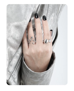 Detail of irregular silver liquid metal rings worn by a model in a minimalist style