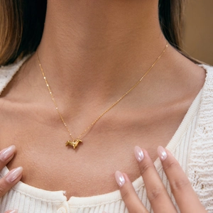 Close-up van de 18K vergulde roestvrijstalen teckel hond hanger ketting bij een model