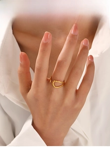 Detail view of 18K gold plated twisted fluid open ring on model with white shirt
