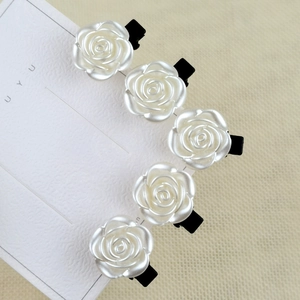 Five-piece set of white camellia hair clips with glossy finish on display card