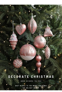 Pink Christmas ornaments with heart and star shapes hanging on a decorated tree