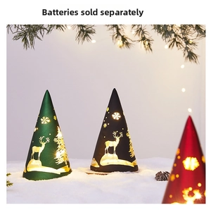 Close-up of conical Christmas night lights with elk and snowflake patterns on snow