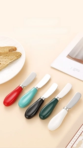 Dettaglio di coltelli da burro con manico in ceramica colorata in acciaio inossidabile