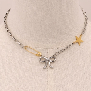 Detalle de collar de lazo bicolor con imperdible y estrellas en cadenas mixtas