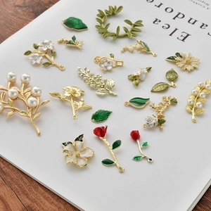 Enamel rose and leaf charms with pearls on vintage magazine background for DIY jewelry