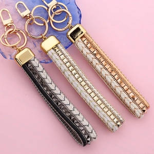 Handwoven tassel keychains in black, silver, and rose gold with metallic rivet details