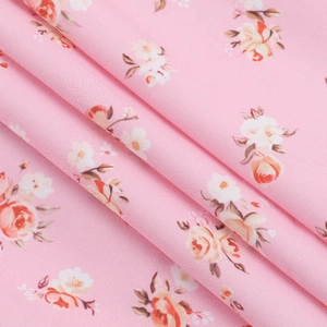 Gros plan du tissu mousseline rose fleuri avec plis élégants et texture très douce