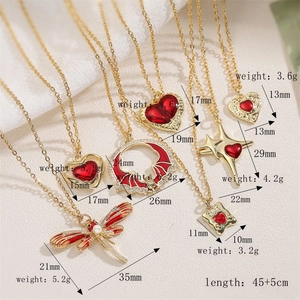 Detailed view of various vintage gold necklaces with red heart and dragonfly pendants