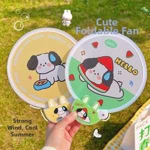 Close-up of cute foldable round hand fans with cartoon dog and watermelon designs