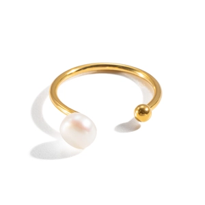 Detalle de un anillo abierto de acero inoxidable dorado con una perla de agua dulce