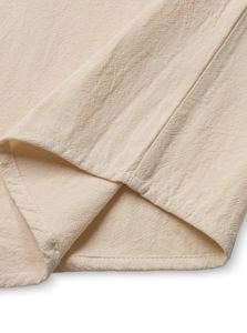 Macro shot of beige cotton linen fabric showing high-density texture and double stitching