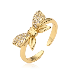 Polished gold-plated adjustable bow ring with micro-pave cubic zirconia on white background