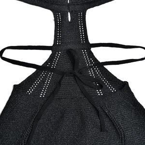 Detail of black knit dress showing backless cutout design and adjustable lace-up ties
