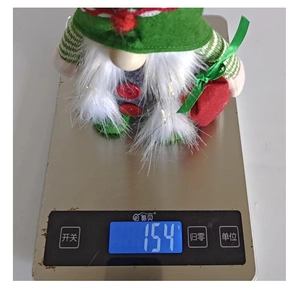 Gnome de Noël pesant 154g sur une balance numérique pour référence de poids et taille