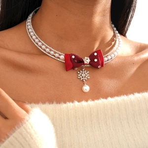 Detail of layered pearl and rhinestone necklace with red bow and snowflake pendant