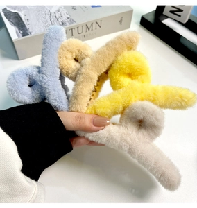 Gros plan de quatre grandes pinces à cheveux en fausse fourrure pelucheuse aux tons pastel