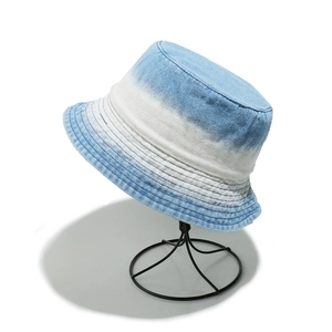 Close-up of gradient washed denim bucket hat featuring multi-row stitched brim detail