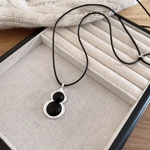 Gros plan du pendentif gourde en argent avec onyx noir sur fond en maille de haute qualité