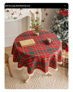 Close-up of red and green plaid round tablecloth with white tassels for Christmas decor