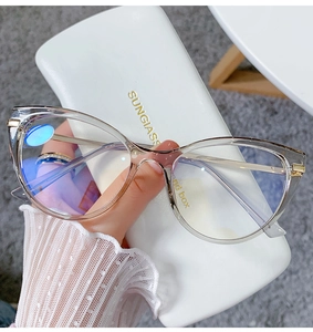 Detail of transparent champagne cat eye frames with gold metal temples and a white case