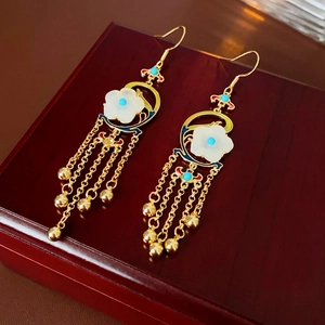 Detail of vintage gold-plated floral earrings with tassels and blue enamel inlay