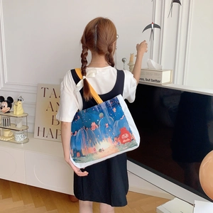 Détail du sac cabas en toile avec imprimé dessin animé étoile et forêt et anses jaunes